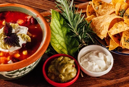 a mexican bean soup board with nachos and toppings